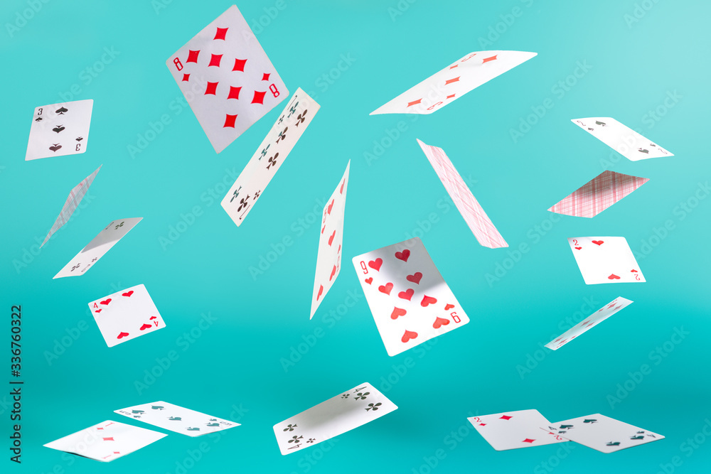 Fotografie flying playing cards on a turquoise background