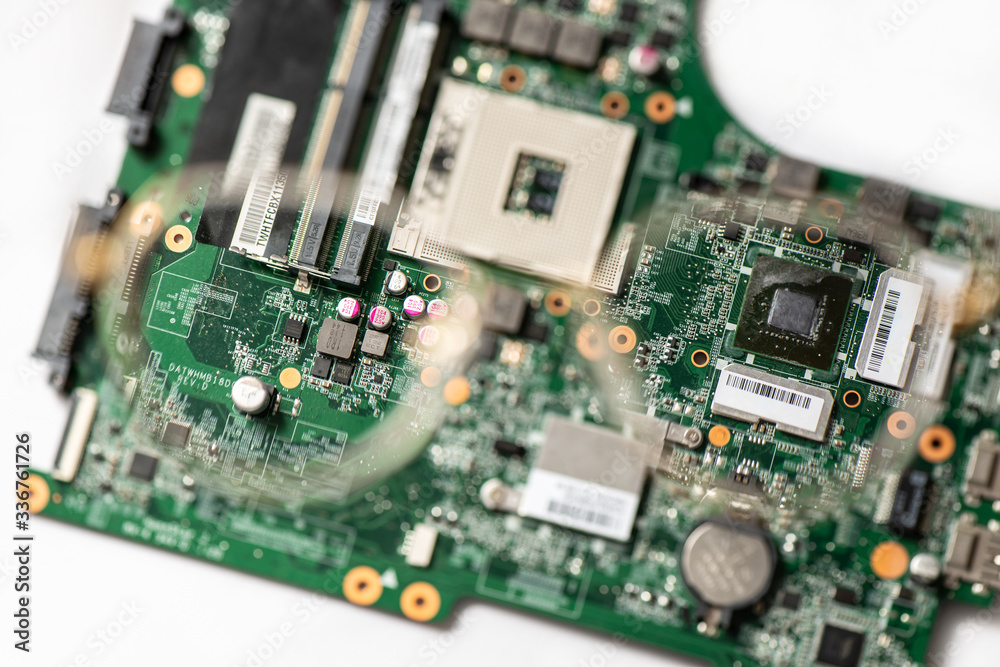 Laptop motherboard closeup. Printed circuit Board with SMD components. view through a magnifying lens of glasses Laptop motherboard closeup. Printed circuit Board with SMD components. view through a magnifying lens of glasses