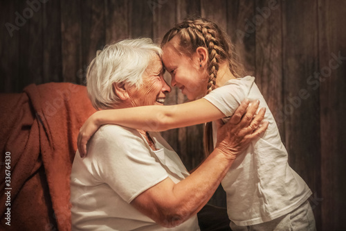 grandmother plays with her granddaughter, depict a plane, hug, time with relatives