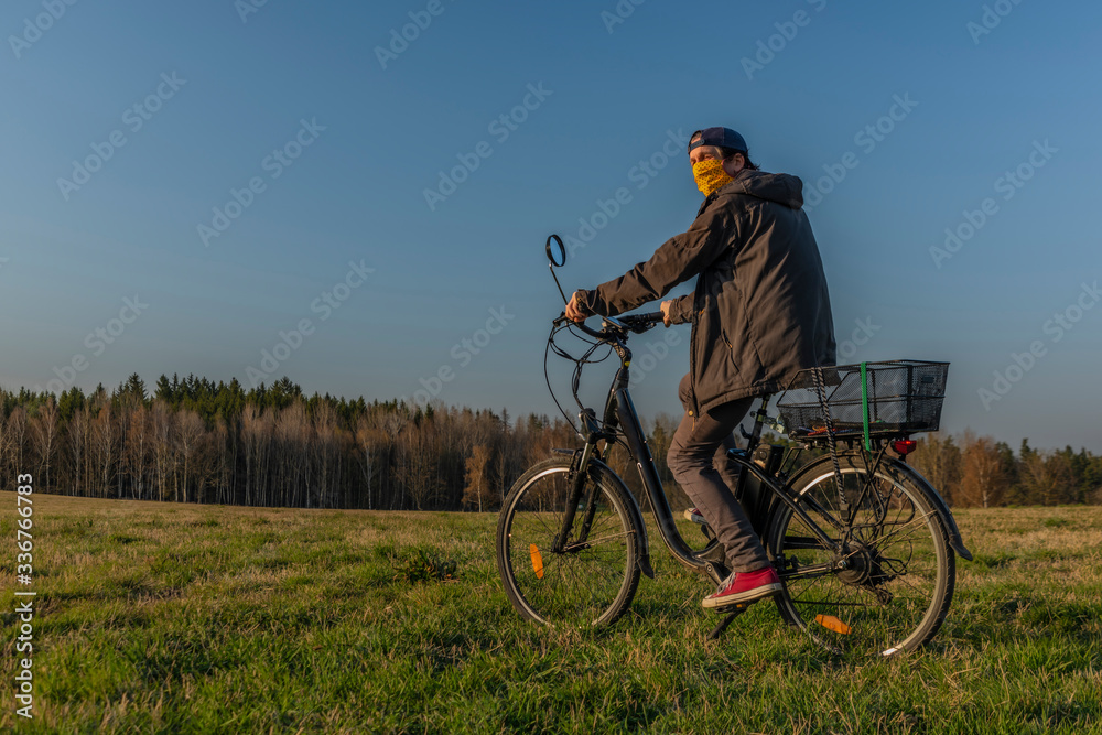 Young man on black electric bike in spring color evening
