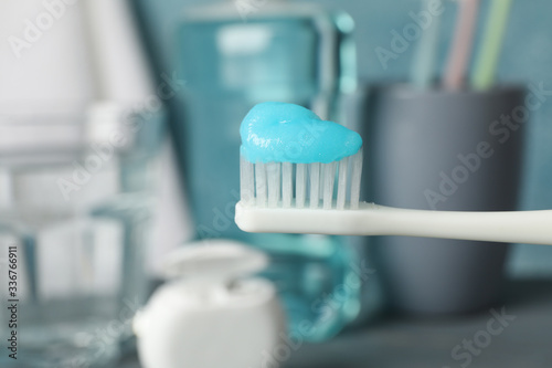 Toothbrush with toothpaste on background with dental care tools, close up