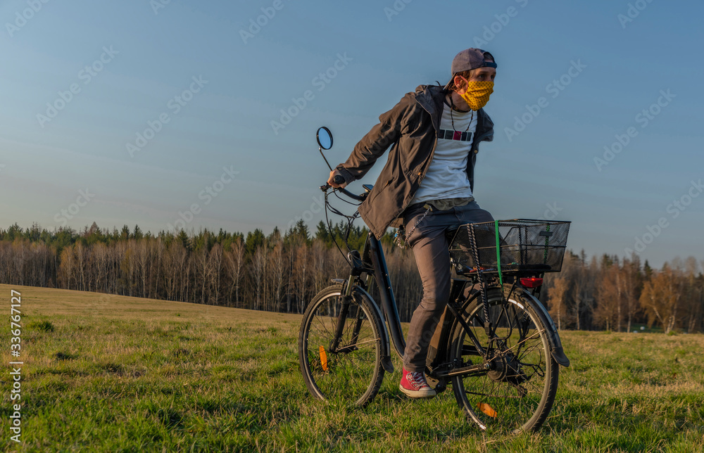 Young man on black electric bike in spring color evening