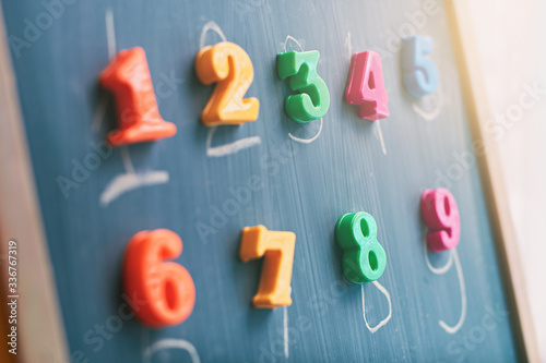 Obraz na płótnie Learning numbers on a blackboard with colorful magnets and handwriting on blackboard during homeschooling at quarantine w salonie