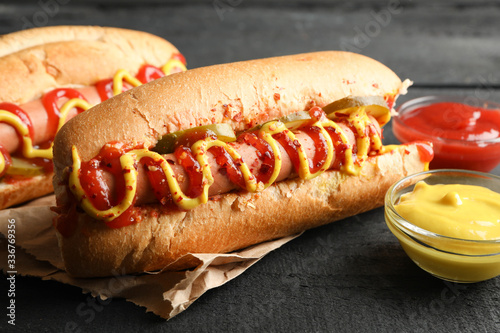 фотографія Tasty hot dogs and sauces on wooden background