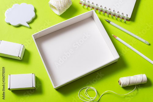 Mock up, empty carton box top view on green background with stationary photo