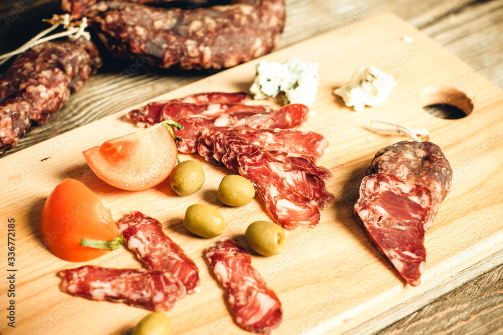 smoked meat and sausage with olives on the kitchen board smoked meat and sausage with olives on the kitchen board