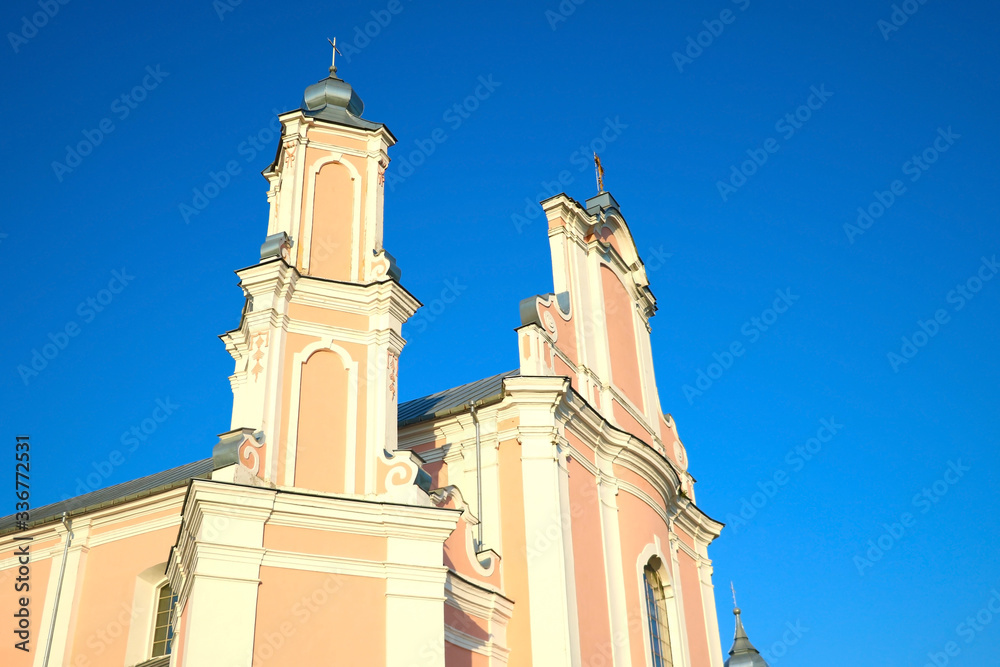 Fototapeta premium Beautiful bright old church on a background of blue sky.