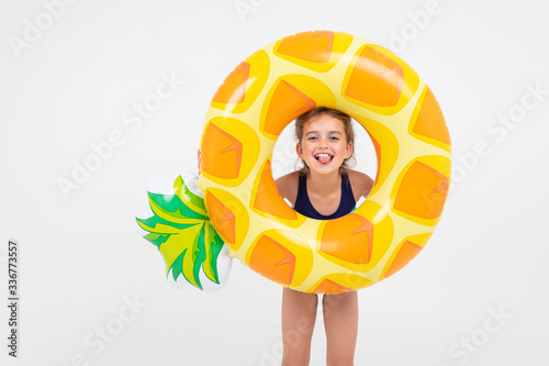sweet girl about to swim in the sea with a rubber ring and a mattress on an isolated white background