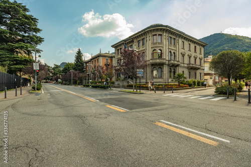Fototapeta Naklejka Na Ścianę i Meble -  Como, ITALY - August 4, 2019: Local people and tourists on a quiet cozy streets in the center of beautiful Italian Como city. Warm sunny summer day in very popular holiday destination