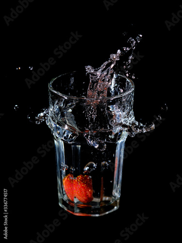 Wasserspritzer durch eine ins Glas fallende Erdbeere