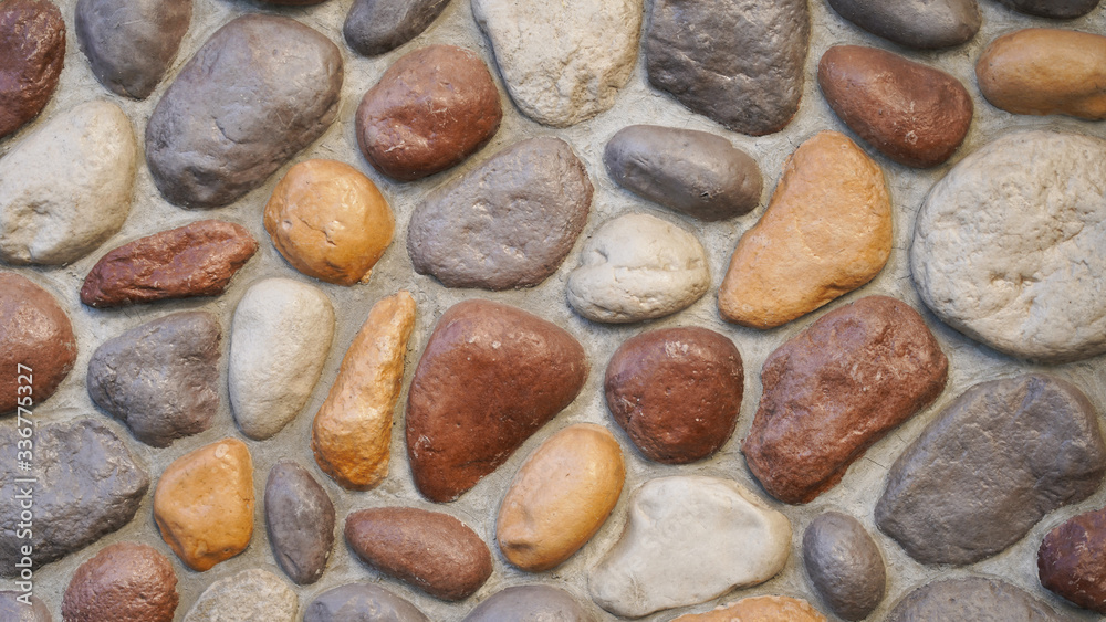 stone wall texture of bright smooth natural stones of different colors. masonry construction stone wall texture of bright smooth natural stones of different colors. masonry construction