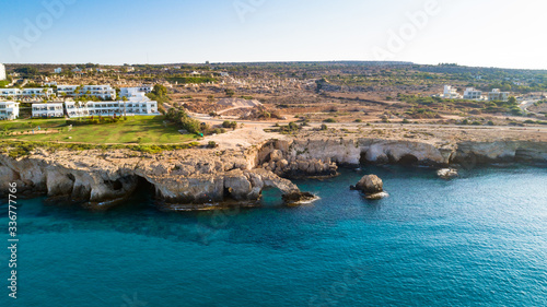 Aerial bird's eye view of Love bridge, international sculpture park and sea caves, at Cavo Greco, Ayia Napa, Famagusta, Cyprus from above. Tourist attraction cliff rock arch in Ammochostos from above.