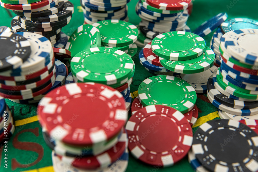 Black white red blue green casino chips stacks on green poker table. Betting club and gamble. Black white red blue green casino chips stacks on green poker table. Betting club and gamble.