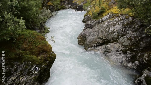 River which is located near path to the Briksdalsbreen (Briksdal) glacier. The melting of this glacier forms waterfall and river with clear water. Jostedalsbreen National Park. Norway. photo