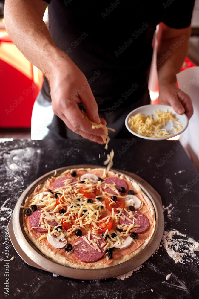 Making pizza at home. Fresh original Italian raw pizza, preparation in traditional style.
