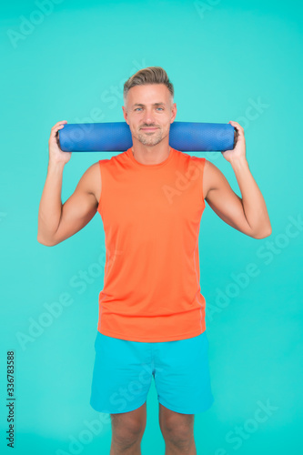 Be training inspiration. Fit man hold yoga mat blue background. Yoga training. Physical training activity. Yoga and pilates. Fitness and sport. Workout at gym. Get started your fitness training