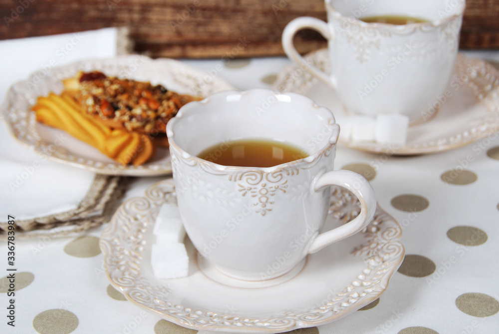 two retro cups with tea, sugar cubes and biscuits for breakfast two retro cups with tea, sugar cubes and biscuits for breakfast