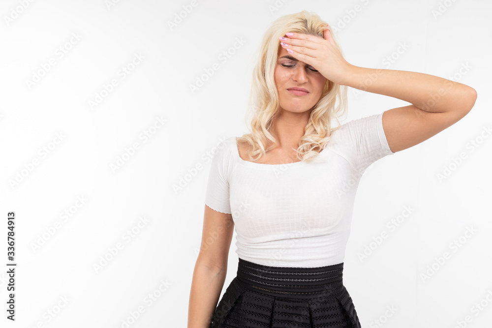 girl feels emotions and holds her hand to her forehead on a white background girl feels emotions and holds her hand to her forehead on a white background