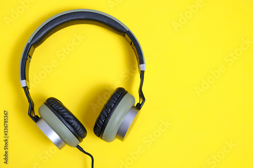 Wired headphones in khaki on a yellow background.
