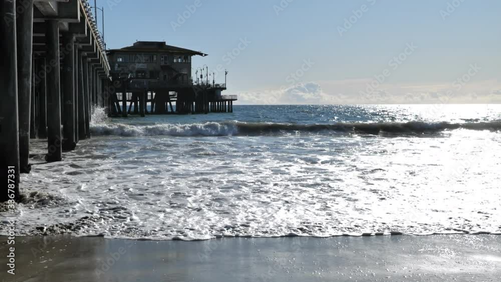 Waves breaking along the Santa Monica Pier in slow motion on a beautiful clear day
