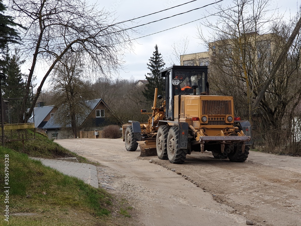 Bulldozer is fixing gravel road surface