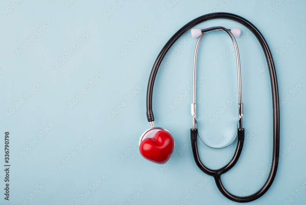 Health care concept. Top overhead above close up view photo of stethoscope and small red heart isolated over blue table background with copy blank empty space for text Health care concept. Top overhead above close up view photo of stethoscope and small red heart isolated over blue table background with copy blank empty space for text