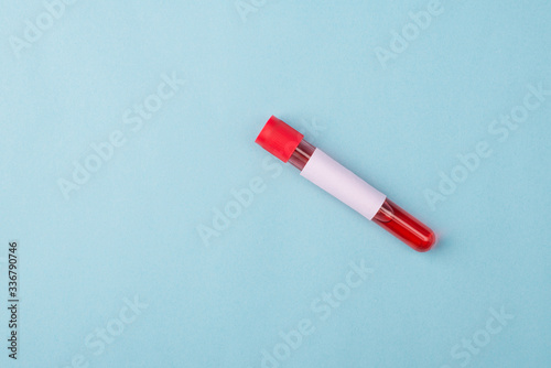 Novel corornavirus test concept. Top above overhead close up view photo of vial with blood sample and label on it isolated over blue color background with copy space