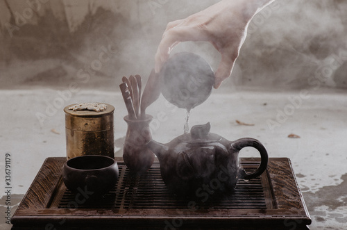 Cropped shot of woman pouring tea in traditional chinese teaware photo