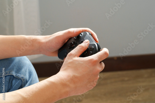 Male hands holding video games joystick at home close up