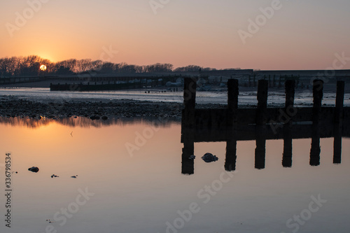 Sunset on Climping Beach in West Sussex, England with beautiful reflections in the water. photo