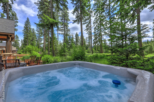 Open hot tub in the back yard with forest and golf course