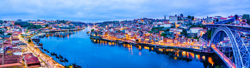 Night cityscape panorama skyline of Porto old town, Luis I Bridge and river Douro banks with reflections.