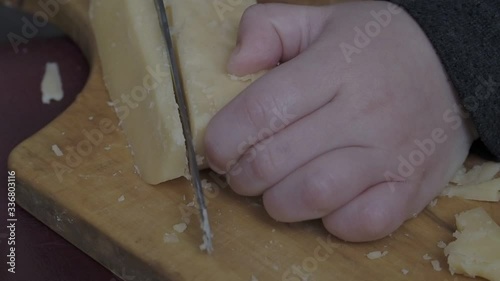 The child cuts the cheese.  A child learns to cut cheese. 