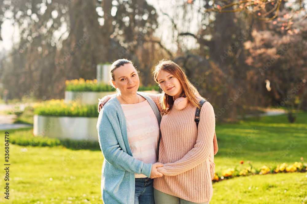 Outdoor portrait of mother and teenage girl in spring sunny park Outdoor portrait of mother and teenage girl in spring sunny park