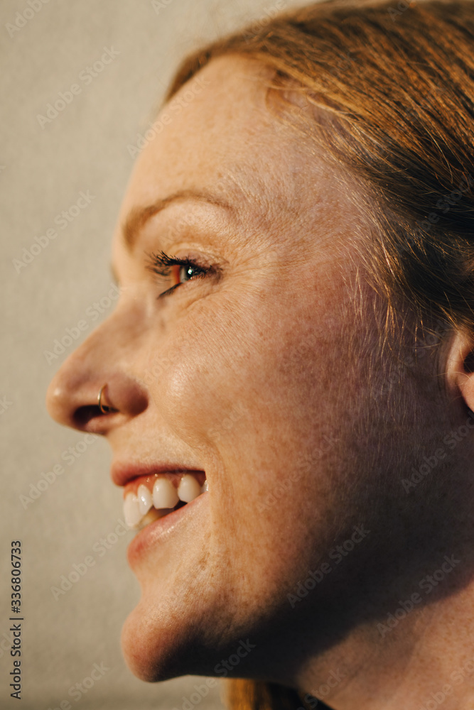 Side view of smiling woman against wall Side view of smiling woman against wall