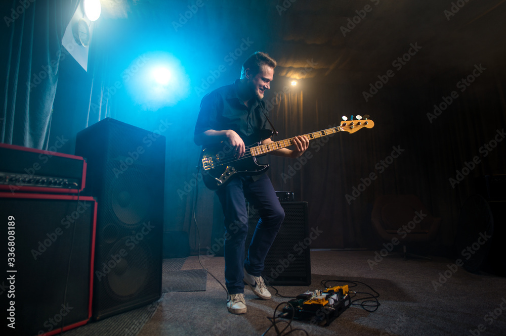Obraz premium Musician playing an electric Bas-guitar on stage