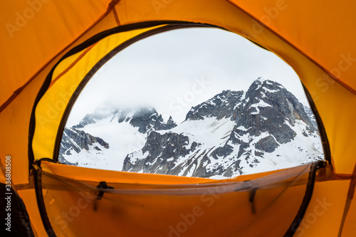 Peeking out a dome tent window at a foggy peak in wild Alaska.