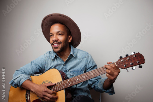 Portrait of happy bearded black man playing guitar isolated on white background. photo
