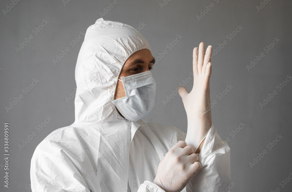 Doctor in white protective suit, medical mask and rubber gloves is ready for helping a people while coronavirus pandemic threat. Epidemic, pandemic of coronavirus covid 19. Doctor in respirator. Doctor in white protective suit, medical mask and rubber gloves is ready for helping a people while coronavirus pandemic threat. Epidemic, pandemic of coronavirus covid 19. Doctor in respirator.