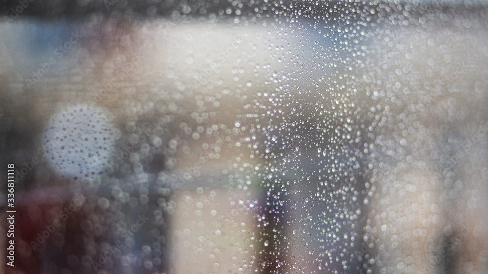 Raindrops on a window glass close up still on a blurry background