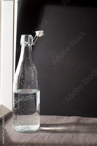The transparent bottle with gas water on the black background.