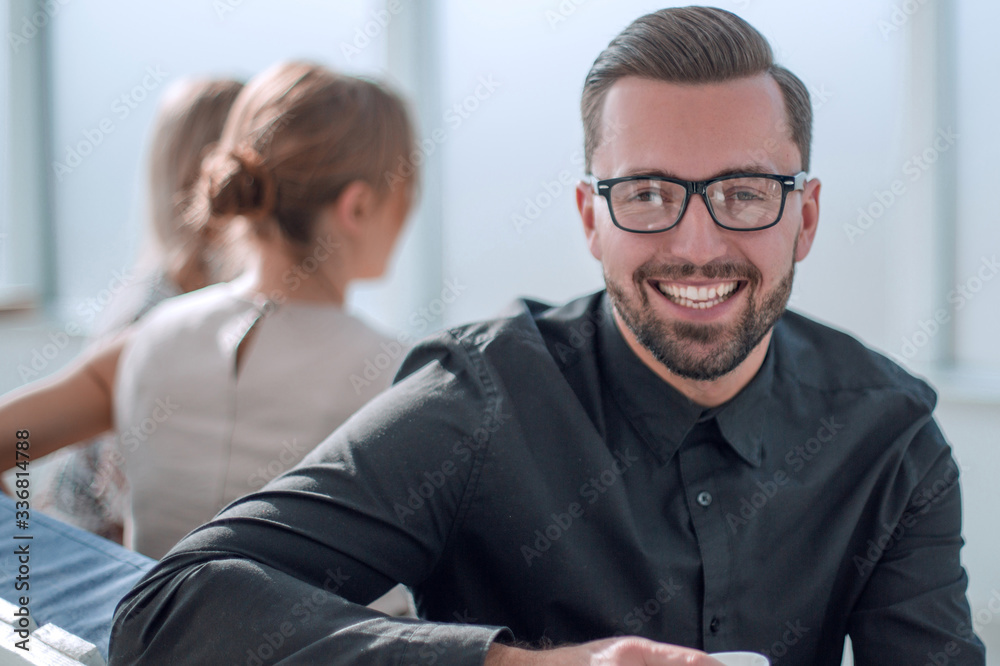 young businessman with a Cup of coffee sitting in a modern office. young businessman with a Cup of coffee sitting in a modern office.