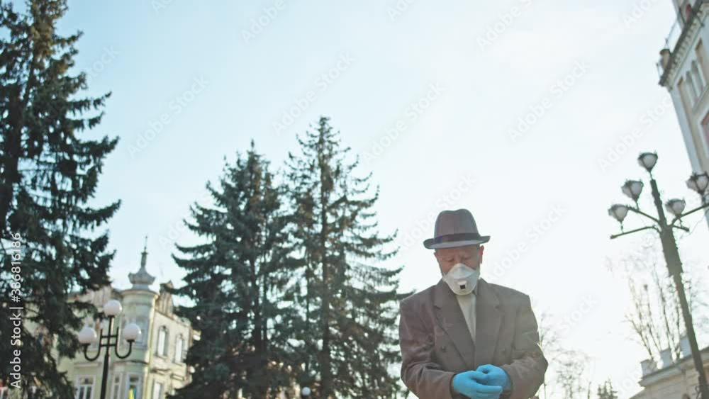 Man walking on street wearing respiratory mask protection health care equipment safety to prevent coronavirus infection. People on quarantine. Pandemic. Man walking on street wearing respiratory mask protection health care equipment safety to prevent coronavirus infection. People on quarantine. Pandemic.