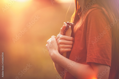 Valokuvatapetti Girl holding a Bible tight as it is the only hope, beautiful warm color palette
