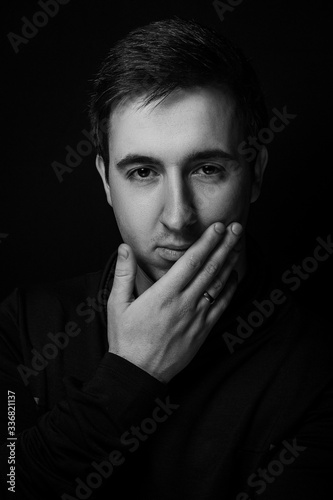 Close-up face of young bearded man on dark background dramatic photo