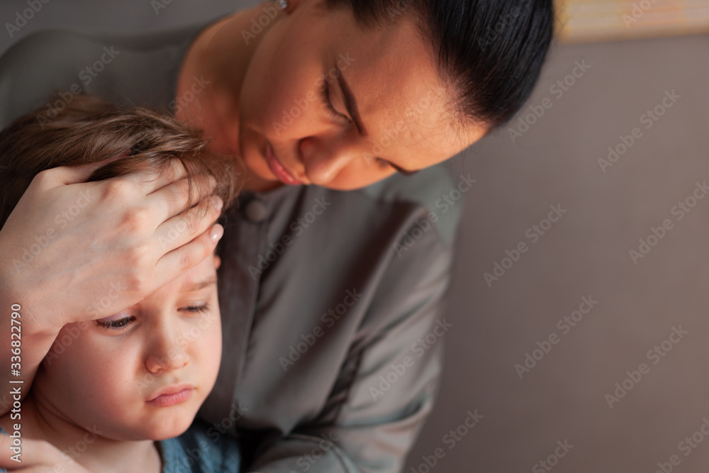 Mother touches the forehead of the child, checking the temperature Mother touches the forehead of the child, checking the temperature