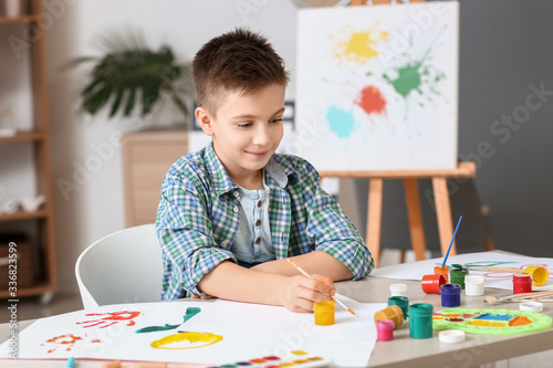 Cute little boy painting at...