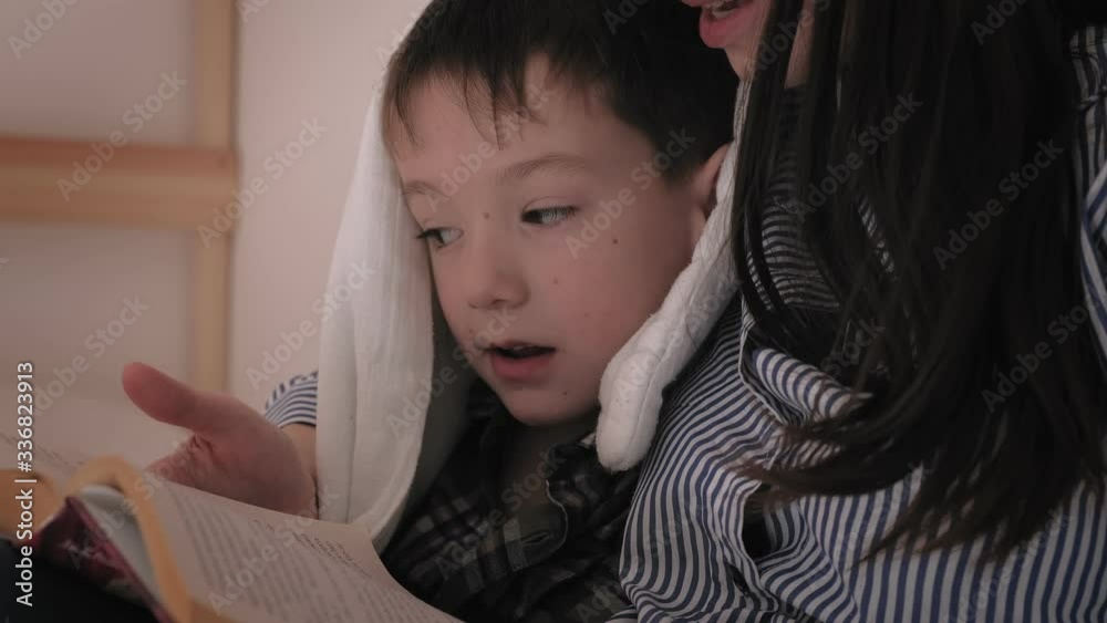 Mom reads a book to her child before going to bed. Insomnia, bad dream Mom reads a book to her child before going to bed. Insomnia, bad dream