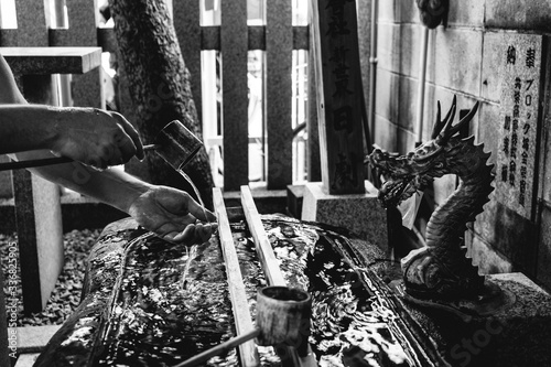 Purify hands with water at shinto shrine, Shinsekai, Osaka, Japan (in black and white) photo