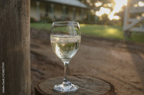 Glass of white wine on country property at sunset